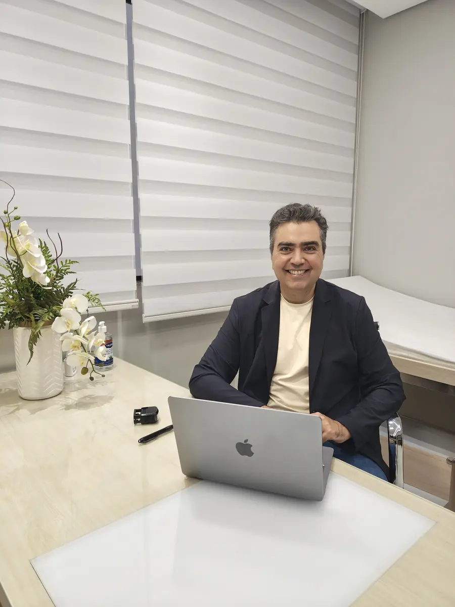 Dr. Ruston Louback em sua mesa no consultório